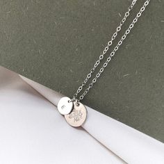 "A sterling silver birth flower necklace that you can personalise! Choose your birth flower on one disc and an initial for the second one. The tiny initial disc pendant sits beside the larger flower one and they hang from a fine sterling silver chain. Each birth flower necklace comes with an elegant card, featuring a vintage illustration and details about what the flower represents. A subtle botanical piece of jewellery, inspired by a love of nature. DIMENSIONS: Pendant: 12mm. Chain: 16-18\" / 4 Delicate Silver Initial Pendant Name Necklace, Delicate Silver Initials Name Necklace, Delicate Silver Initial Pendant Necklace, Minimalist Flower Charm Necklace For Personalized Gift, Minimalist Birth Flower Charm Necklace With Initial Pendant, Minimalist Initial Pendant Charm Necklace With Birth Flower, Minimalist Birth Flower Initial Pendant Charm Necklace, Minimalist Birth Flower Initial Pendant Necklace, Delicate Silver Pendant Initial Necklace