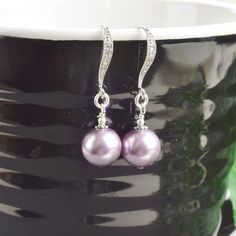 "Pearl drop earrings featuring a beautiful mauve lavender pearl on cubic zirconia and rhodium plated ear wires. The purple earrings measure 1\" long and would make the perfect bridesmaids earrings. Multiples are available at checkout at discounted pricing. Message me if you don't see the quantity you need. I will make a lisitng for you. * rhodium plated ear wires with cubic zirconia * swarovski pearls The earrings will arrive gift boxed. The matching bracelet, as shown in picture #4, is availabl Mother Of The Bride Jewelry, Purple Dangle Earrings, Bridesmaid Pearl Earrings, Snowflake Jewelry, Bridesmaids Earrings, Wedding Party Gifts, Bridesmaid Pearls, Bride Jewelry, Earrings Purple