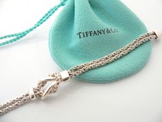 Do you know which items made Tiffany a world renowned company? You just stumbled upon one of them! Offered for sale is a wonderful vintage Tiffany and Co. Sterling Silver Double Rope Love Knot bracelet - in a rare longer length - 7.75 inches. The piece is made from solid and substantial Tiffany silver, yet has a very delicate and feminine feel to it. The bracelet is very unique - hard to find and come by, so grab it while you have the chance! It is very pretty worn on its own, but would also wor Luxury Sterling Silver Jubilee Bracelet As Gift, Luxury Chain Bracelet With Sterling Silver Clasp As Gift, Elegant Sterling Silver Bracelet With Clasp For Gift, Engraved Chain Bracelet For Formal Occasions, Elegant Sterling Silver Bracelet With Box Clasp As Gift, Elegant Chain Bracelet With Clasp As Gift, Luxury Bracelets With Sterling Silver Clasp For Anniversary, Elegant Silver Bracelet With Hallmarks, Vintage White Gold Chain Bracelet For Formal Occasions