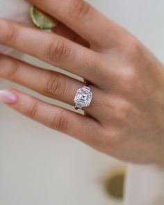 a woman's hand with a diamond ring on it