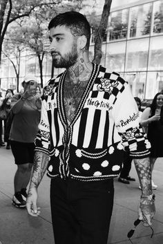 a man with tattoos walking down the street