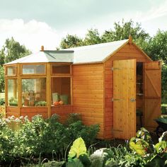 a small wooden shed sitting in the middle of a garden