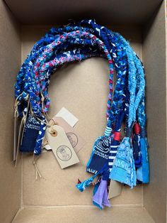 an open box with various items in it and tags attached to the string on each side