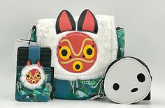 a small purse with an animal face on it and a keychain next to it