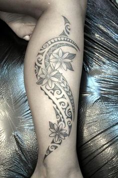 a woman's leg with a tattoo on it and flowers in the shape of a crescent