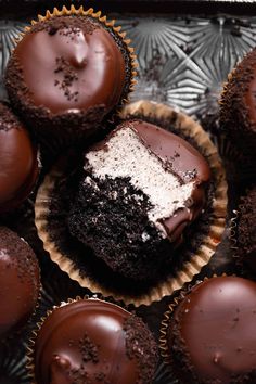 chocolate cupcakes with white frosting and sprinkles arranged on a tray