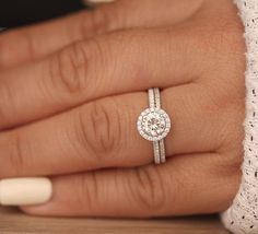 a close up of a person's hand with a diamond ring on their finger