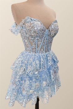 This blue, tulle A-line dress features a semi-sheer bodice with structured boning, off-the-shoulder styling, festive lace appliques, and a lace-up back closure for a chic mini silhouette. Off-shoulder Prom Dress With Corset Back, Lace Mini Dress For Cocktail Events During Prom Season, Off-shoulder Gala Dress With Corset Back, Prom Off-shoulder Corset Back Corset Dress, Light Blue Dress With Corset Back And Fitted Bodice, Off-shoulder Corset Back Prom Dress, Off-shoulder Corset Dress With Fitted Bodice For Prom, Party Dress With Lined Bodice And Off-shoulder Design, Off-shoulder Party Dress With Lined Bodice