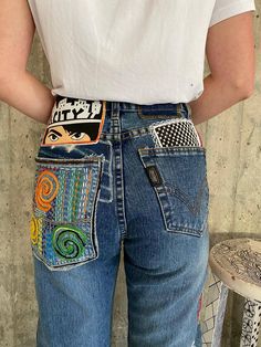 "Ready to send:size- 28 unique vintage jeans one of a kind.. hand made embroidery and unique patches. ---Or---- Made to order, in any size, within 12 working days . If you need different size, please send me a message and I will make you a special and unique design within 12 working days. They are all different! No one will have the same one as you have! Hand painted, one of kind jeans. You pick your size, model (slime- boyfriend- high waist- low waist) and primer color and you will get your sin Multicolor Denim Bottoms With Patches, Retro Cotton Jeans With Graphic Print, Multicolor Denim Bottoms For Festival, Multicolor Graphic Print Denim Bottoms, Recycled Denim Bottoms With Patches For Streetwear, Streetwear Recycled Denim Bottoms With Patches, Streetwear Bottoms With Patches In Recycled Denim, Retro Straight Leg Jeans With Graphic Print, Upcycled Blue Bottoms For Festivals