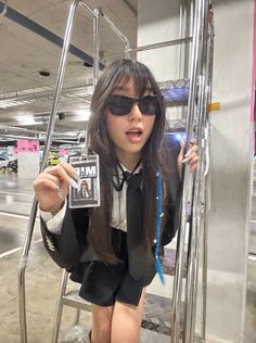 a woman wearing sunglasses holding up a magazine