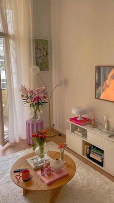 a living room filled with furniture and a painting on the wall next to a window