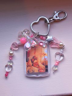 a keychain with a photo and charms attached to it