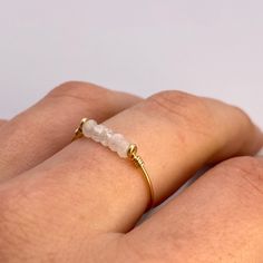 This beautifully simple ring is lovingly handmade with 5 tiny Moonstones and a choice of 14k Gold Filled, 14k Rose Gold Filled or Sterling Silver band. M A T E R I A L S: * Rainbow Moonstone * 14k Gold Filled, 14k Rose Gold Filled or Sterling Silver S I Z E: *  Gemstone - Approximately 2mm each *  Band Thickness - Approximately 0.8-1mm  All of our jewellery is carefully handmade using good quality materials and handpicked gemstones, with the aim to produce quality pieces that you can love & wear Handmade Minimalist 14k Gold Filled Ring, Minimalist Adjustable Crystal Ring With Round Band, Delicate Adjustable 14k Gold-filled Rings, Adjustable Delicate 14k Gold Filled Rings, Adjustable Stackable Moonstone Ring For Everyday, Handmade 14k Gold Crystal Promise Ring, Handmade 14k Gold Crystal Ring For Promise, Dainty 14k Gold Crystal Ring For Everyday, Delicate Adjustable 14k Gold Filled Stackable Rings