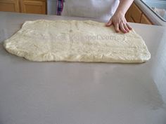 a woman is kneading dough on top of a counter