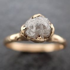 a gold ring with a rough diamond in the center