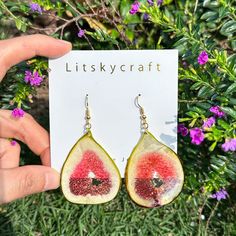 a pair of earrings with watermelon slices hanging from it's ear hooks