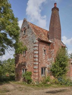 an old brick building with a chimney and windows