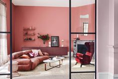 a living room with pink walls and furniture