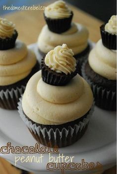 cupcakes with white frosting sitting on top of a cake plate in front of the words chocolate peanut butter cupcakes