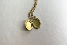 This sweet, small, OVAL antique brass locket has a smooth Labradorite cabochon set on the front.  It hangs on a 16" gold stainless steel chain necklace.  The locket is approximately 11x16mm.  The cabochon is 6x8mm.  Arrives in an eco-friendly jewelry box, ready for gifting. MORE lockets in my shop! FREE SHIPPING! THANK YOU FOR VISITING MY SHOP! Nickel-free Brass Medallion Charm Necklaces, Brass Medallion Locket Charm Necklaces, Brass Medallion Locket Charm Necklace, Dainty Brass Locket Charm Necklace, Brass Pendant Locket Charm Necklace, Gold Brass Dainty Locket Necklace, Dainty Brass Locket Necklace, Gold Dainty Brass Locket Necklace, Dainty Gold Brass Locket Necklace