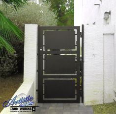 an open black door in the side of a white wall next to a planter