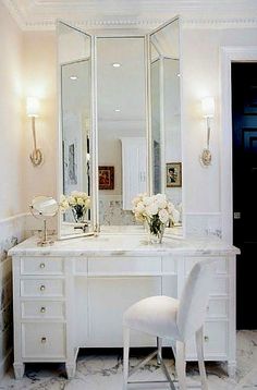 a white chair sitting in front of a bathroom vanity