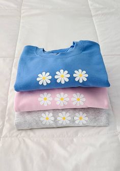 "This crewneck is soooo soft and cute! It has 3 daisies in the center and it comes in 3 different colors and 5 different sizes! ☆ DETAILS ☆ ▪︎ Available in blue, pink, and light gray. 💙 ▪︎ 50% Cotton, 50% Polyester ▪︎ Three 1.5\" daisy flowers 🌼 ▪︎ Available in sizes Small, Medium, Large, X Large, and XXL 👕 ▪︎ Gildan G180 Crewnecks ▪︎ Message me if you have any questions! 💕" Spring Light Blue Crew Neck Sweatshirt, Light Blue Crew Neck Sweatshirt For Spring, Trendy Light Blue Sweatshirt For Spring, Light Blue Sweatshirt For Spring Loungewear, Cute Sweatshirt For Spring Loungewear, Daisy Sweatshirt, Tie Dye Crewneck Sweatshirts, Womens Sweatshirts, Daisy Flowers