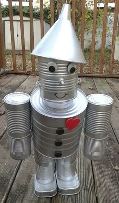 a tin can robot sitting on top of a wooden deck