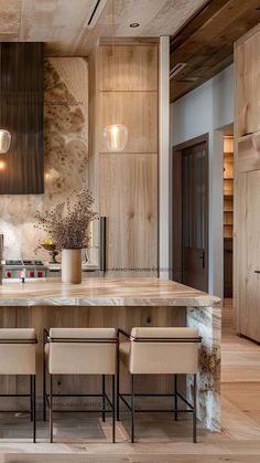 a kitchen with marble counter tops and wooden cabinets, along with beige leather dining chairs