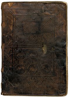 an old leather book with intricate designs on the cover