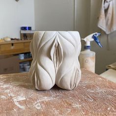 a white vase sitting on top of a wooden table