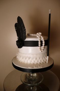 a white and black cake with feathers on top