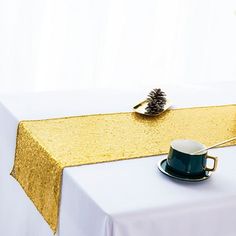 a table topped with a cup and saucer on top of a white table cloth