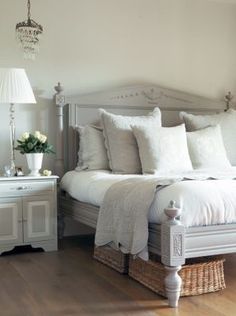 a bedroom with a large bed and white furniture