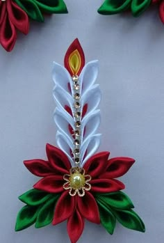 a red and white flower with green leaves attached to it's centerpieces