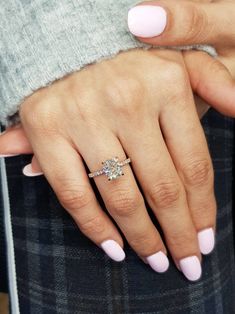 a woman's hand with pink manicured nails and a ring on her finger