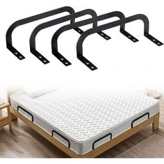 four black metal bed rails on top of a white mattress in a room with wooden flooring