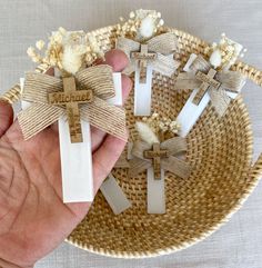 someone is holding some small crosses in their hand and they are decorated with burlap