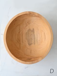 a wooden bowl sitting on top of a white counter