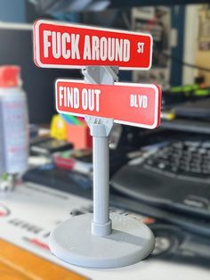 two red and white street signs sitting on top of a desk next to a keyboard