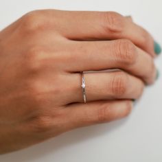 a woman's hand with a diamond ring on it