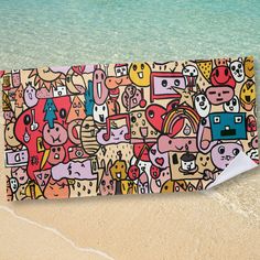 an image of a beach towel with cartoon characters on it and the ocean in the background