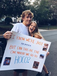 a man and woman holding a sign that says it know we're just friends but can this be the one where we go to hoo?