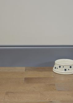 a dog bowl sitting on the floor next to a wall