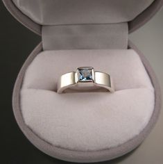 "5 mm square scissors-cut blue Topaz is bezel set with stout 2mm thick by 5mm wide rectangular band. These are beautifully cut, eye clean stones with top sky blue color. I can make this ring for you in any size between 5 and 11. Pictured ring is size 7 for scale. Specify your ring size in a \"note to seller\" at checkout." Rectangular Tension Setting Ring As A Gift, Silver Topaz Ring With Rectangular Blue Stone, Silver Blue Topaz Ring With Rectangular Stone, Gift Blue Topaz Ring With Rectangular Shape, Modern Rectangular Sapphire Ring For Anniversary, Gift Blue Topaz Rectangular Ring, Modern Rectangular Sapphire Anniversary Ring, Modern Rectangular Blue Topaz Ring, Modern Rectangular Topaz Wedding Ring