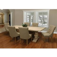 a dining room table and chairs in front of a large window with wood flooring