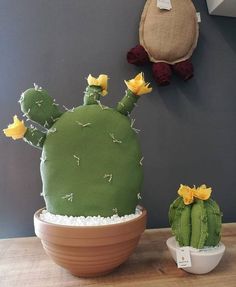 a cactus shaped cake sitting on top of a table next to a potted plant