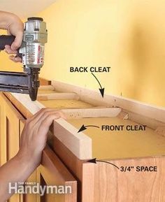 a person using a power tool to attach cabinet drawers