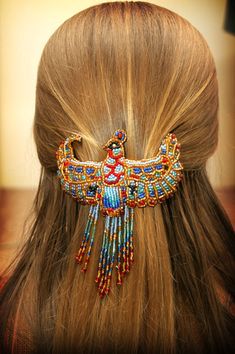 the back of a woman's head wearing a hair comb with colorful beads on it