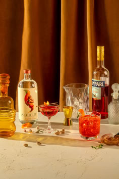 bottles and glasses filled with different types of alcohol on a table next to each other